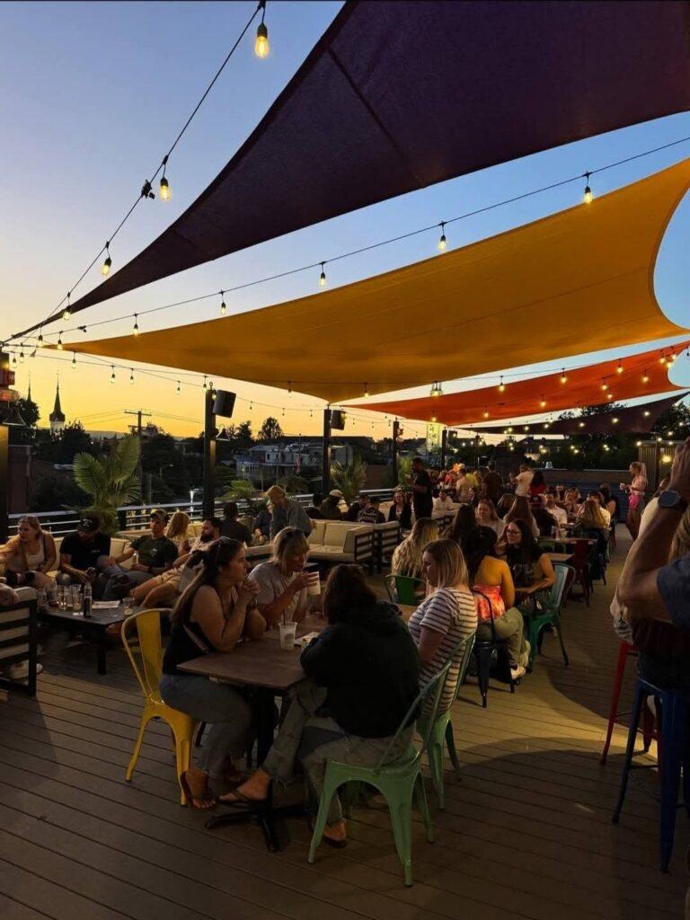 People gathered under custom shade sails for rooftop bar